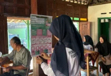 "Mahasiswa Profesi Fisioterapis UMS menunjukkan poster edukasi tentang cara mencegah Nyeri Punggung Bawah (Low Back Pain) kepada para kader PKK dan lansia di Desa Nguter, Sukoharjo, yang sedang mengikuti kegiatan Posbindu."