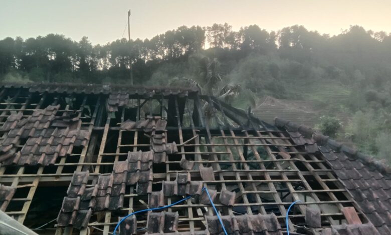 Atap rumah warga rusak parah dan hangus akibat peristiwa kebakaran di area perbukitan.