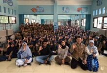 Sekelompok besar siswa SD Muhammadiyah Danaraja berpakaian Pramuka dan narasumber internasional berpose 'oke' di lantai saat MPLS.