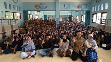 Sekelompok besar siswa SD Muhammadiyah Danaraja berpakaian Pramuka dan narasumber internasional berpose 'oke' di lantai saat MPLS.