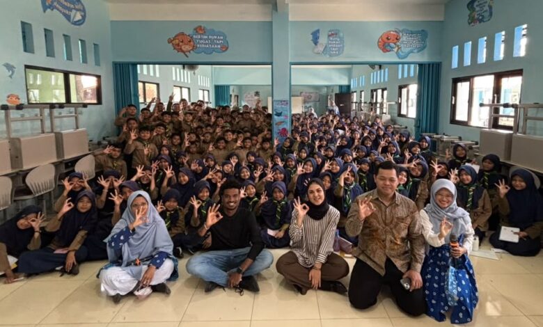 Sekelompok besar siswa SD Muhammadiyah Danaraja berpakaian Pramuka dan narasumber internasional berpose 'oke' di lantai saat MPLS.
