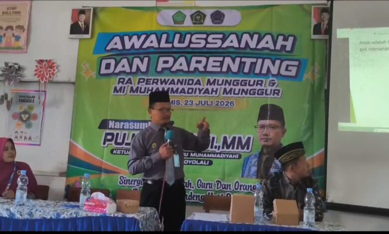 Seorang narasumber berdiri menyampaikan materi di depan banner acara Awalussanah dan Parenting RA Perwanida Munggur serta MI Muhammadiyah Munggur.