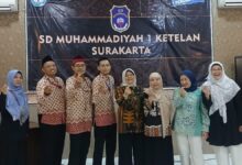 Tim riset UPI Bandung dan pihak SD Muhammadiyah 1 Surakarta saat tinjauan kurikulum koding dan sekolah dasar AI, serentak berfoto dengan pose jari 'love'.