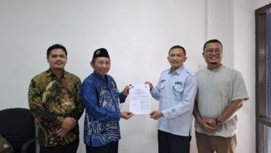 Empat orang pria berpose bersama sambil memegang dokumen kerja sama, salah satunya mengenakan seragam biru berlogo UMS.