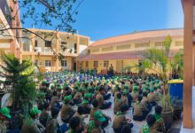 Ratusan siswa berseragam pramuka duduk rapi di halaman sekolah mendengarkan pengarahan.
