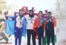 Atlet pencak silat Indonesia asal UMS Kirana Tias Savira berdiri di podium juara satu memegang bendera Merah Putih usai meraih medali emas pada 10th Asian Pencak Silat Championship 2026 di Dong Nai Vietnam.