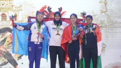 Atlet pencak silat Indonesia asal UMS Kirana Tias Savira berdiri di podium juara satu memegang bendera Merah Putih usai meraih medali emas pada 10th Asian Pencak Silat Championship 2026 di Dong Nai Vietnam.