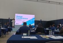 Suasana forum konferensi internasional bertajuk Global Conference dengan pembicara di atas panggung dan audiens yang menyimak di dalam ruangan.