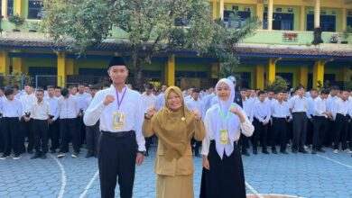 Kepala sekolah berfoto bersama dua perwakilan siswa baru peserta MPLS SMA Muhammadiyah 1 Temanggung 2026 di halaman sekolah.