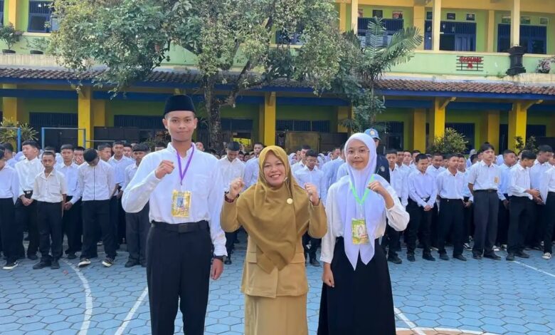 Kepala sekolah berfoto bersama dua perwakilan siswa baru peserta MPLS SMA Muhammadiyah 1 Temanggung 2026 di halaman sekolah.