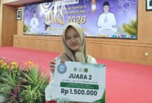 Siswa putri SMP Mutual Magelang berhijab memegang papan penghargaan Juara 2 kategori Hifdzil 1 Juz dan Tilawah Putri pada ajang Musabaqah Tilawatil Qur’an (MTQ) Tingkat Kota Magelang Tahun 2026, dengan latar belakang panggung acara.