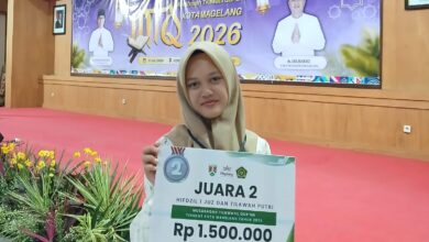 Siswa putri SMP Mutual Magelang berhijab memegang papan penghargaan Juara 2 kategori Hifdzil 1 Juz dan Tilawah Putri pada ajang Musabaqah Tilawatil Qur’an (MTQ) Tingkat Kota Magelang Tahun 2026, dengan latar belakang panggung acara.