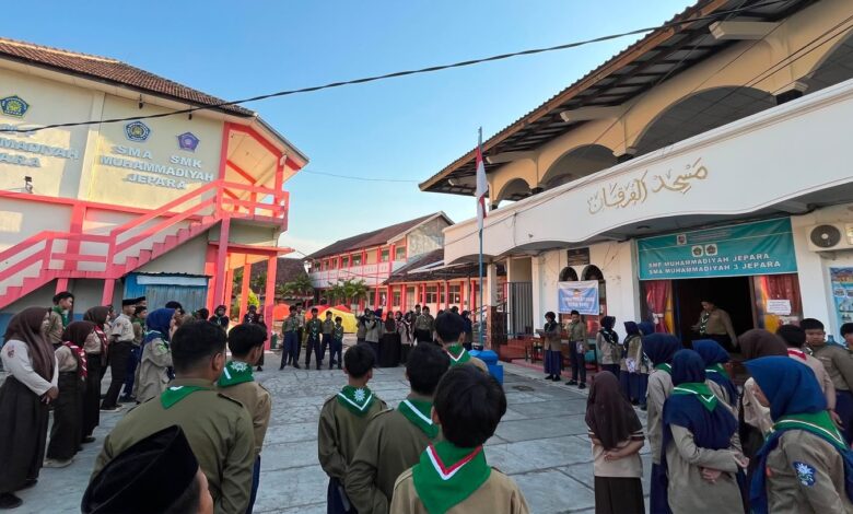 Sekelompok siswa pramuka SMP Muhammadiyah Jepara sedang melaksanakan upacara pembukaan atau penutupan kegiatan Kemah Taaruf di halaman sekolah pada pagi hari yang cerah, dikelilingi gedung sekolah dan masjid.