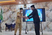 Sertijab Kepala SMP Muhammadiyah 1 Dayeuhluhur: Penyerahan dokumen jabatan oleh Ika Yunita kepada Eka Susila di depan layar monitor