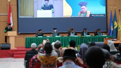 Mendikdasmen Abdul Mu'ti (tampilan di layar besar sebelah kanan) saat menyampaikan sambutan dalam Sidang Promosi Doktor Muhammad Khoirul Huda di Pascasarjana UNJ.