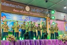 Sekumpulan pelajar berpakaian seragam pengakap mempersembahkan tarian atau persembahan seni di atas pentas berhias kain ungu.