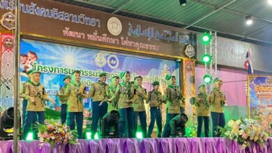 Sekumpulan pelajar berpakaian seragam pengakap mempersembahkan tarian atau persembahan seni di atas pentas berhias kain ungu.