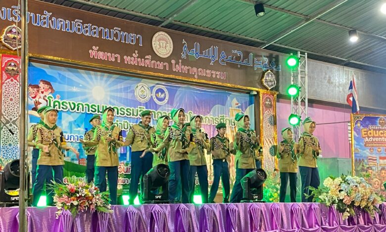 Sekumpulan pelajar berpakaian seragam pengakap mempersembahkan tarian atau persembahan seni di atas pentas berhias kain ungu.
