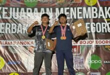 Aqnar Dzakyarta, mahasiswa UMP, berpose di podium dengan medali emas dan perunggu pada Kejuaraan Menembak Perbakin Tingkat Nasional di Bojonegoro.