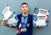 Caesar Al Ayyubi atlet renang pelajar menunjukkan piagam dan medali dalam ajang Kejuaraan Renang Salatiga