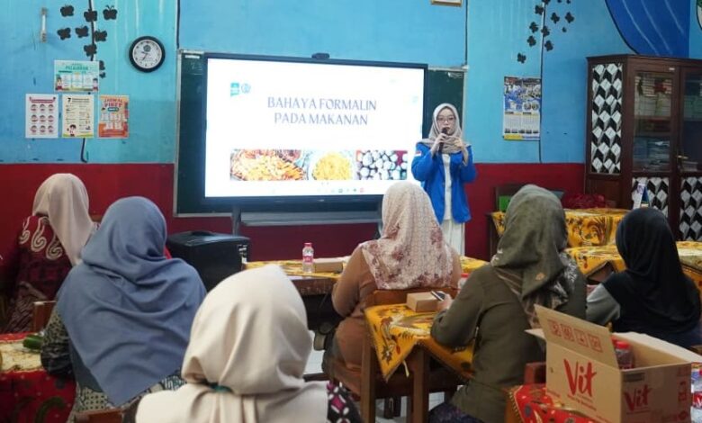 Mahasiswa UMP sedang memberikan pemaparan materi mengenai bahaya formalin pada makanan kepada orang tua murid di dalam ruang kelas SDN 2 Dukuwaluh.