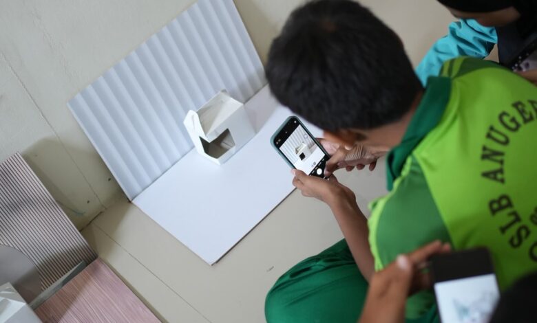 Siswa SLB Anugerah Karanganyar memotret kemasan produk putih dengan smartphone dalam pelatihan fotografi produk digital UMS.