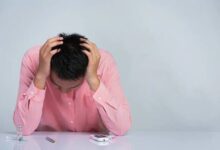 Pria tampak stres memegang kepala di meja berisi alat cek gula darah dan insulin