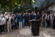 Tim pengabdian UMP bersama warga foto bersama di dekat alat pembakar sampah digital UMP berbahan oli bekas di Purbalingga Lor.