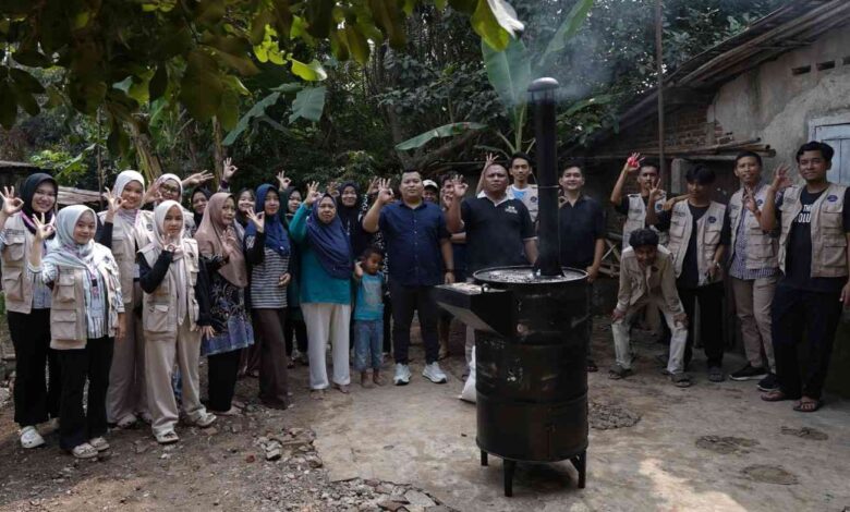 Tim pengabdian UMP bersama warga foto bersama di dekat alat pembakar sampah digital UMP berbahan oli bekas di Purbalingga Lor.