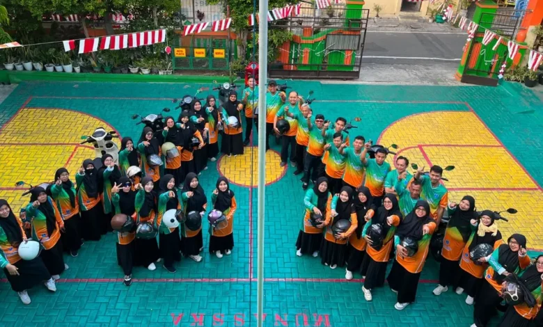 Guru dan tenaga kependidikan SD Muhammadiyah 16 Surakarta berfoto bersama membawa helm sebelum berangkat touring capacity building ke Kemuning