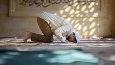 Seorang pria sedang sujud saat melaksanakan sholat di dalam masjid.