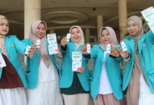 Lima mahasiswa UMS mengenakan jas almamater hijau toska memperlihatkan produk dan brosur deodoran alami pencegah bau badan BIOSHIELD-DEO.