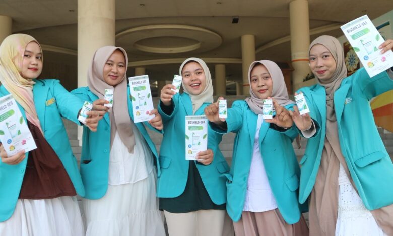 Lima mahasiswa UMS mengenakan jas almamater hijau toska memperlihatkan produk dan brosur deodoran alami pencegah bau badan BIOSHIELD-DEO.
