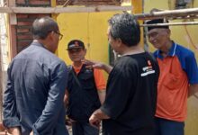 Ketua PCM Kedungwuni Mustami'an berbincang dengan relawan dan Mbah Danali di lokasi program Bedah Rumah LAZISMU Pekalongan.