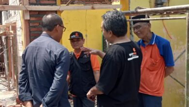 Ketua PCM Kedungwuni Mustami'an berbincang dengan relawan dan Mbah Danali di lokasi program Bedah Rumah LAZISMU Pekalongan.