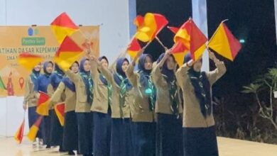 Siswa berhijab menampilkan atraksi bendera semapur saat LDK SMA Muhammadiyah 1 Bangsri di Gua Sakti Plajan.