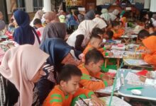 Suasana peserta anak-anak didampingi orang tua mengikuti lomba mewarnai dan menggambar Cilacap di Balai Desa Dayeuhluhur.