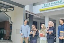 Mahasiswa Farmasi UMS sedang berjalan dan berdiskusi di depan gedung OSCE Farmasi Universitas Muhammadiyah Surakarta