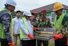 Mendikdasmen Abdul Mu’ti memegang prasasti dan mikrofon dalam acara pembangunan RKB SD Plus Muhammadiyah Sinabang di Aceh.