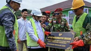Mendikdasmen Abdul Mu’ti memegang prasasti dan mikrofon dalam acara pembangunan RKB SD Plus Muhammadiyah Sinabang di Aceh.