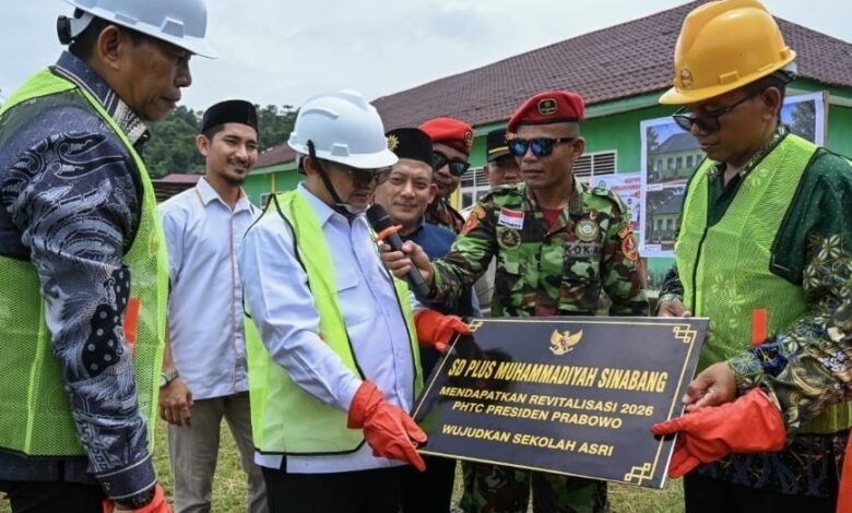 Mendikdasmen Abdul Mu’ti memegang prasasti dan mikrofon dalam acara pembangunan RKB SD Plus Muhammadiyah Sinabang di Aceh.