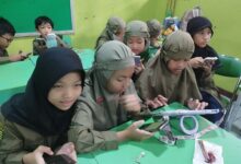 Siswa SD Muhammadiyah 1 Solo mengoperasikan smartphone di dalam kelas untuk menulis berita.
