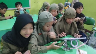Siswa SD Muhammadiyah 1 Solo mengoperasikan smartphone di dalam kelas untuk menulis berita.