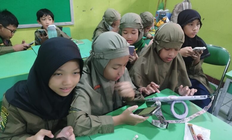 Siswa SD Muhammadiyah 1 Solo mengoperasikan smartphone di dalam kelas untuk menulis berita.