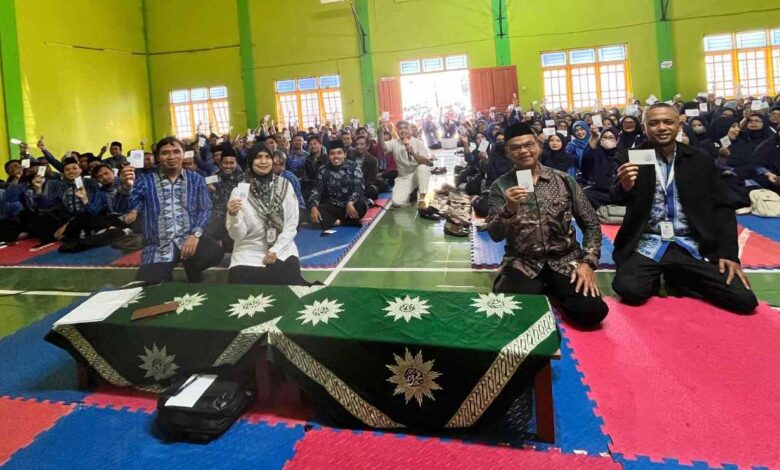 Narasumber Babe Aries dan Ketua K3M MURIA Wonosobo Yuwono bersama para guru berpose memegang kartu komitmen gerakan STOP untuk mencegah bullying di sekolah ramah anak.
