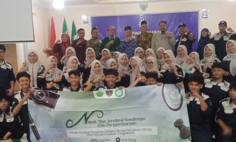 Puluhan siswa SMA Muhammadiyah 3 Yogyakarta dalam acara napak tilas Jenderal Soedirman di Cilacap, berpose bersama panitia sambil membentangkan spanduk kegiatan.