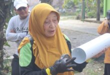 Dra Sri Widayatuti memegang pipa paralon lubang biopori untuk pengelolaan sampah rumah tangga di Desa Ploso Demak