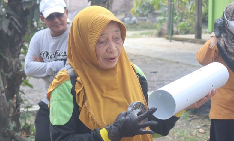 Dra Sri Widayatuti memegang pipa paralon lubang biopori untuk pengelolaan sampah rumah tangga di Desa Ploso Demak