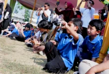 Murid SD Muhammadiyah PK Solo berkaos biru sedang membidikkan kamera saat praktik liputan Hari Anak Nasional 2026 di Taman Lingkar Lokananta.