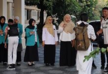 Mahasiswa PLP 2 UMS menyambut dan berinteraksi ramah dengan siswa SMPN 1 Surakarta di area halaman sekolah.